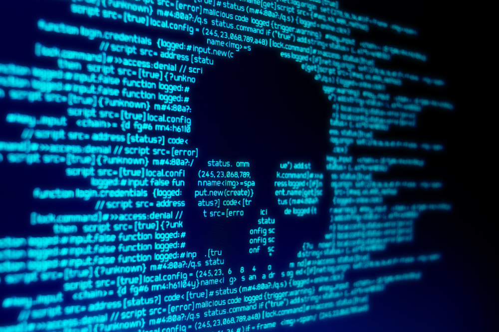 Computer code on a screen with a skull representing a computer virus / malware attack